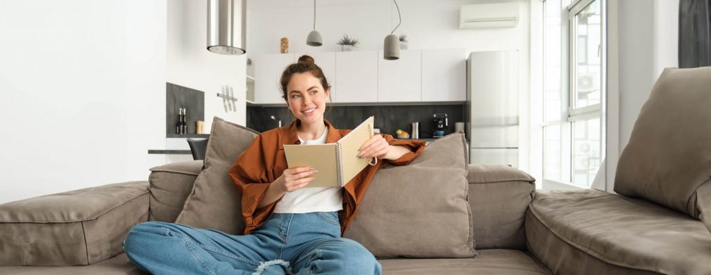 Gas Boiler Installation From Elite Heating and Cooling. Happy Customer sitting on the couch enjoying the comfortable Tempature in her house because of Elite Heating and Cooling Elite Gas Boiler Installation